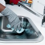 Person putzt Waschbecken