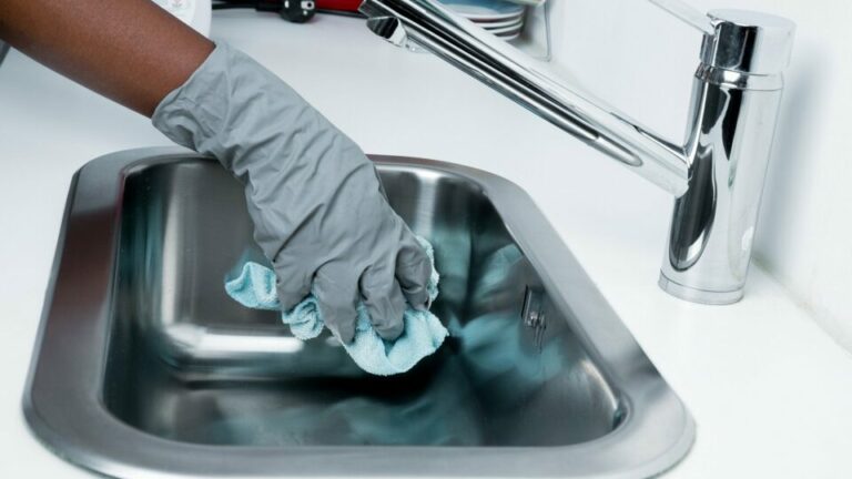 Person putzt Waschbecken