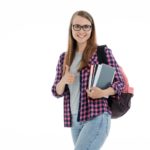 Frau mit Rucksack und Büchern schaut in die Kamera und zeigt Daumen hoch