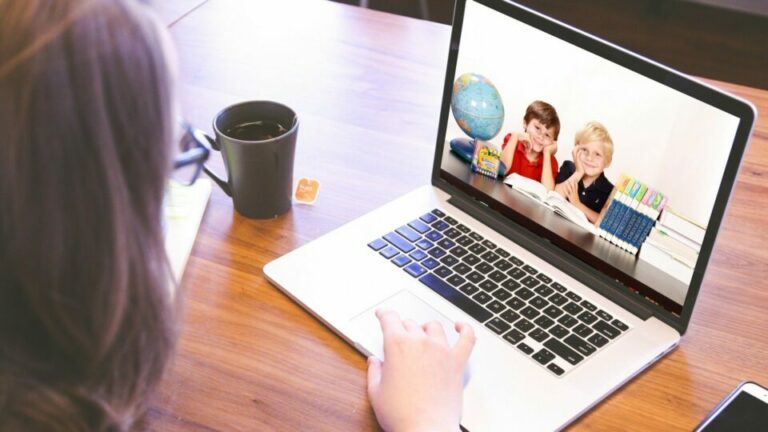 Frau blickt auf einen Laptop.