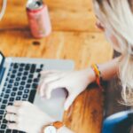 Frau tippt an einem Laptop