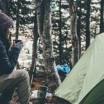 Frau beim Campen mit einer Tasse Tee
