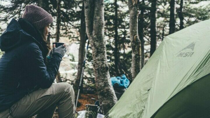 Frau beim Campen mit einer Tasse Tee