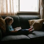 Kind mit Buch auf der Couch