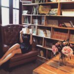 woman-g8d5f6ab56_1920 Frau in Bilbiothek hält sich ein Buch vor's Gesicht