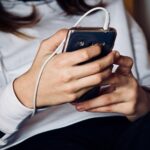 Nahaufnahme eines Mädchens das ein Smartphone bedient.