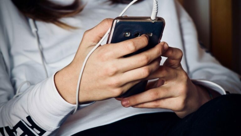 Nahaufnahme eines Mädchens das ein Smartphone bedient.