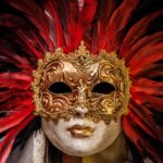 Skulptur mit goldener Maske und rot-schwarzen Federn