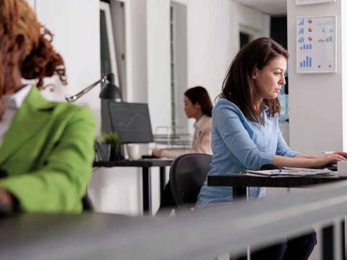 Blick in ein Büro. Man sieht drei Frauen die konzentriert arbeiten
