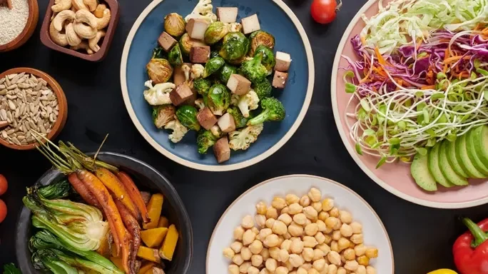 Ein Tisch mit gesunden veganen Produkten auf Tellern und Schüsseln