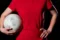 Mädchen in roter Kleidung hält einen Ball unter dem Arm