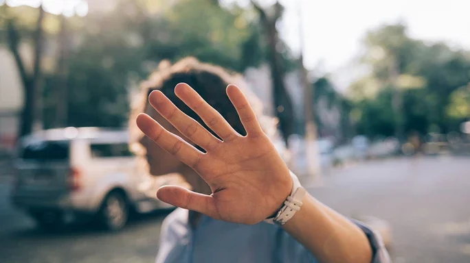 Person zeigt die Hand in die Kamere als möchte sie nicht fotografiert werden.