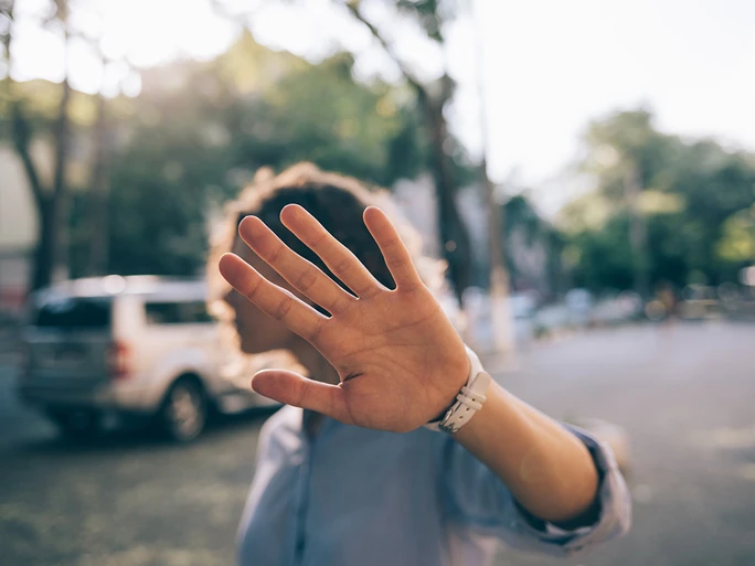 Person zeigt die Hand in die Kamere als möchte sie nicht fotografiert werden.