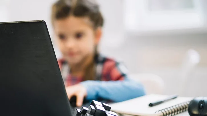 Kleines Mädchen sitzt am Labtop