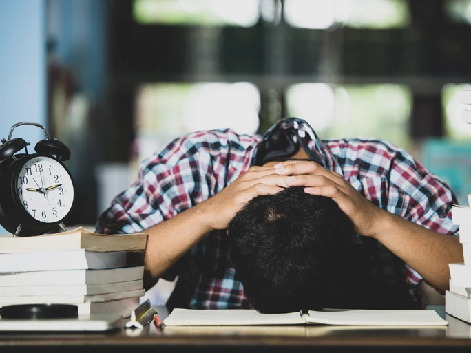 Symbolbild für den TK-Gesundheitsreport 2023. Es zeigt einen erschöpften Studenten.