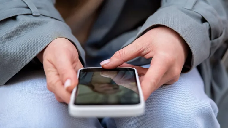 Nahaufnahme auf Hände die ein Smartphone bedienen.