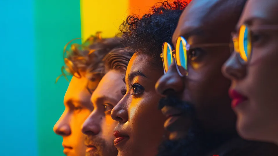 Diverse Personen vor einem Regenbogenhintergrund