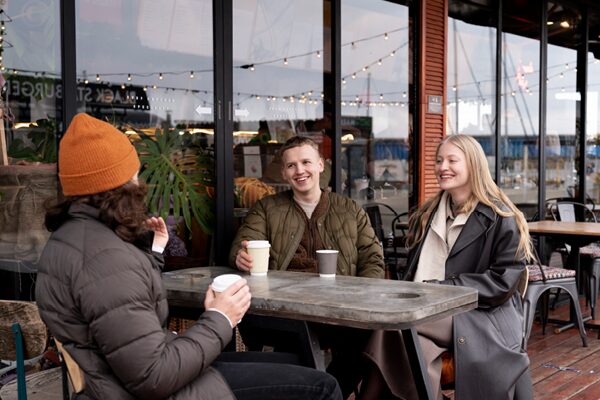 3 junge Menschen in einem Kaffee