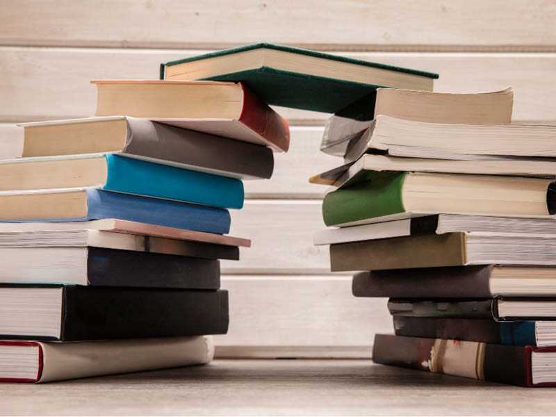 Zu einer Brücke augestapelte Bücher