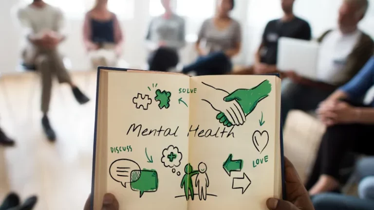 Eine Diskussionsgruppe man sieht aus der Ego-Perspektive ein aufgeschlagenes Notizbuch mit Illustrationen zum Thema Mental Health.