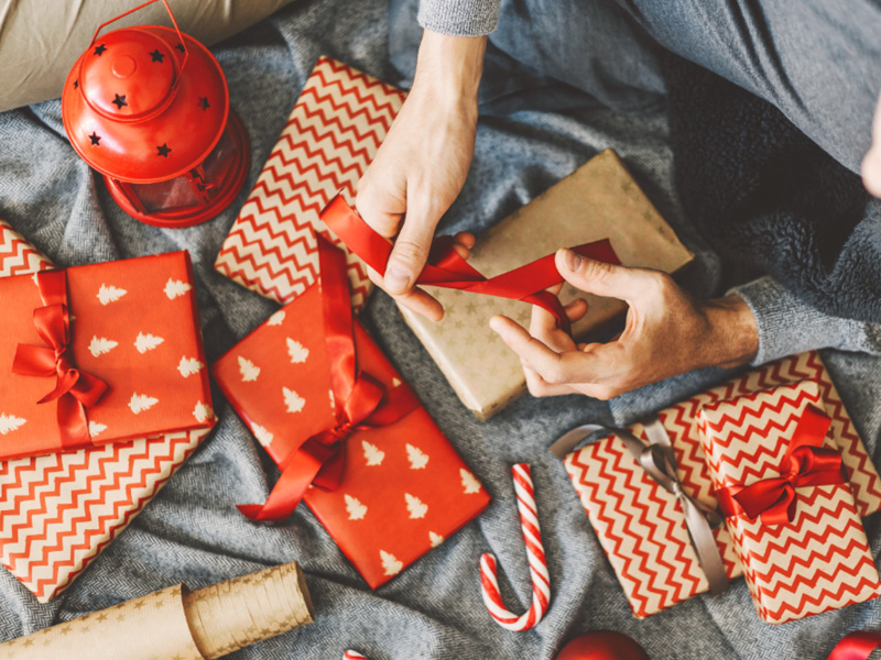 Ein Mann der Weihnachtsgeschenke verpackt